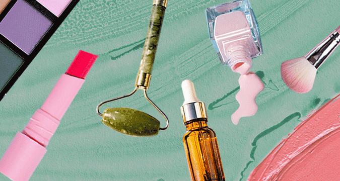 Personal care, beauty and cosmetics products — lipstick, jade roller, serum dropper, nail polish and makeup brush on a pastel background